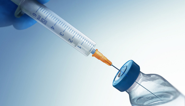 Syringe drawing a cortisone injection from a vial.