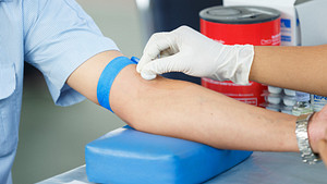 Arm being cleaned with a cotton ball for a blood test